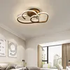 A bedroom with a modern ceiling lamp, two framed pictures on the wall, and a large window with curtains. Náhled obrázku produktu