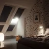 A bedroom with skylights, a bed, and a lamp. Produktbild-Vorschau