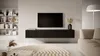 A modern living room with a wall-mounted TV unit. Produktbild-Vorschau