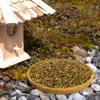 A bird feeder with birdseed in a wooden bowl, a bird, and a birdhouse in a natural outdoor setting. Produktbild-Vorschau
