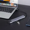 A USB-C hub is connected to a laptop, with a USB drive plugged into the hub and a smartphone next to it. Produktbild-Vorschau