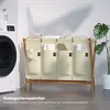 A laundry basket with four compartments is shown next to a washing machine, with a plant in the background. Anteprima dell’immagine prodotto