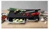 A black cutting board with integrated drawers filled with sliced zucchini and other vegetables, along with a knife and other kitchen utensils on a wooden countertop. Voir les images du produit