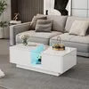 A modern living room with a gray sectional sofa and a white high-gloss coffee table with LED lighting. Produktbild-Vorschau