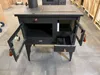 A black wood-burning stove with its doors open, displayed indoors. Anteprima dell’immagine prodotto