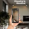 A hand holding a smartphone displaying a room with ceiling lights. Produktbild-Vorschau