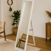A full-length mirror stands in a room with a chair and a plant. Náhľad obrázku produktu