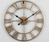 A close-up of a vintage-style metal wall clock with Roman numerals. Produktbild-Vorschau