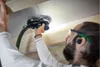 A man is using a Festool Akku-Exzenterschleifer ETSC 2 150 4,0 I-Plus to sand a ceiling in a workshop. Voir les images du produit