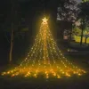 A star-shaped waterfall light decoration is set up in a garden at night. Produktbild-Vorschau