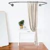 A shower curtain rod with a curtain hanging from it, placed above a white table with plants. Produktbild-Vorschau