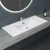 A white sink is installed on a gray countertop, with a round illuminated mirror in the background. Produktbild-Vorschau