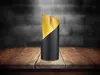 A table lamp with a black base and gold interior is placed on a wooden table in front of a dark brick wall. Voir les images du produit