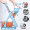 A person is using a blue vegetable slicer to cut carrots. The slicer has a large feed port and a collection bin. Voir les images du produit