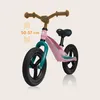 A pink balance bike is shown against a light beige background. Text indicating handlebar height adjustment is visible. Produktbild-Vorschau