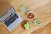 A laptop and a meal prep container set are arranged on a wooden table. Voir les images du produit
