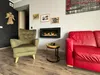 A living room scene featuring a fireplace, armchair, and sofa. Anteprima dell’immagine prodotto