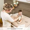 A mother changing her baby on a changing pad. Produktbild-Vorschau