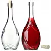 Two glass bottles, one empty and one filled with red liquid, with a cork stopper next to them. Voir les images du produit
