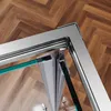 A close-up view of a shower enclosure corner, showing the metal frame and glass panels. Produktbild-Vorschau