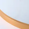 A close-up view of the edge of a round mirror with a gold frame. Produktbild-Vorschau