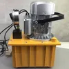 A hydraulic pump unit with a motor and pressure gauge is shown on a table. Podgląd zdjęcia produktu