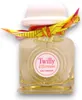 A bottle of Hermes Twilly Eau Ginger perfume with a decorative scarf tied around the neck. Anteprima dell’immagine prodotto