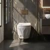 A modern bathroom with a wall-mounted toilet, marble-patterned walls, and a vanity with a sink and faucet. Podgląd zdjęcia produktu