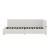 A white upholstered bed frame with a slatted base, shown from the side. Voir les images du produit
