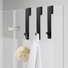 Black hooks hanging on a glass shower door, holding a loofah and a towel. Produktbild-Vorschau