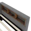 A close-up view of the headboard of a bed, showing built-in shelves and a charging port. Produktbild-Vorschau