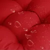 A close-up of a red tufted cushion with water droplets on its surface. Produktbild-Vorschau