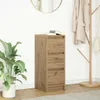 A wooden cabinet with books on top, a plant to the left, and a coat rack with clothes to the right, in a room. Produktbild-Vorschau