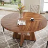 A round wooden dining table with a vase of flowers, a magazine, and a cup of coffee on it, placed in a dining room setting with a tufted chair and a patterned rug. Podgląd zdjęcia produktu