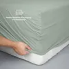 A hand is shown stretching a fitted sheet over a mattress. Produktbild-Vorschau