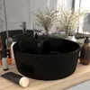 A black ceramic sink with a silver faucet is displayed on a wooden countertop, surrounded by toiletries and decorative plants. Náhled obrázku produktu