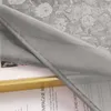 A close-up of a gray sheer curtain with a floral pattern visible underneath. Produktbild-Vorschau