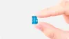 A hand is holding a small blue microSD card. Podgląd zdjęcia produktu