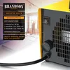 A close-up of a yellow and black heater with a diagram explaining its features and controls, set against a blurred background of a room under renovation. Produktbild-Vorschau