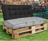 A pallet sofa with gray and black cushions sits on grass in a garden setting. Náhled obrázku produktu