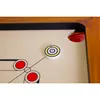 A close-up view of a carrom board with a striker and red pieces. Produktbild-Vorschau
