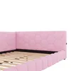 A close-up view of a pink upholstered bed frame with a hexagonal pattern on the headboard and side rails. The wooden slats of the bed base are visible. Podgląd zdjęcia produktu