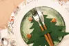 A festive Christmas table setting with a plate, cutlery, and decorative elements. Produktbild-Vorschau