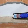A sealant gun is applying sealant to a gap between brick and a white surface. Anteprima dell’immagine prodotto