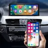 A smartphone is being held up in front of a car's dashboard, with the car's infotainment screen displaying a smartphone interface. Produktbild-Vorschau