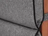 A close-up view of a gray fabric cushion with black piping, attached to a wooden surface. Produktbild-Vorschau