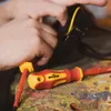 Hands working on a black object with a yellow stripe, with screwdrivers on a colorful workbench. Produktbild-Vorschau