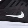 A close-up view of the side of a black Nike shoe, showing the Nike swoosh logo. Voir les images du produit