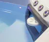 Close-up view of a white disc with a flower-like pattern, floating in blue water, next to a gray handle with three purple-accented buttons. Produktbild-Vorschau