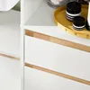 Close-up view of a white cabinet with wooden accents, showing two drawers. Anteprima dell’immagine prodotto